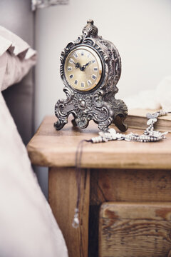 Wooden nightstand with vintage clock and jewellery