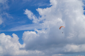 Paragliding in the cloudy blue sky.