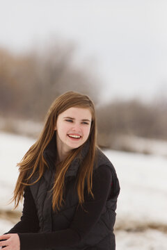 Teen smiling while preparing to throw snowballs