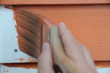 Applying Fresh Coat of Orange Paint to Home