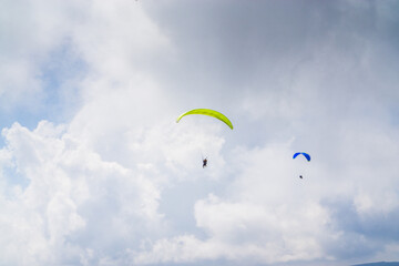 Paragliding in the cloudy blue sky.