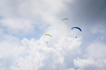 Paragliding in the cloudy blue sky.