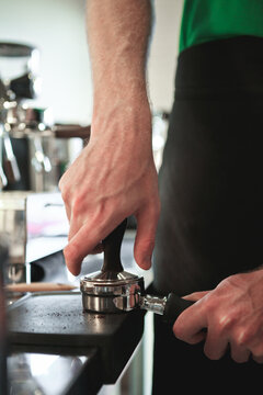 Close up of man's hands tamping espresso