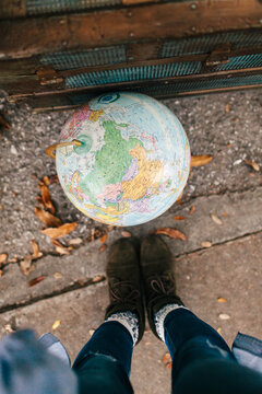 A woman looking down at a world globe