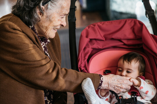 Senior woman playing with a baby - Family moment of great grandmother and great granddaughter