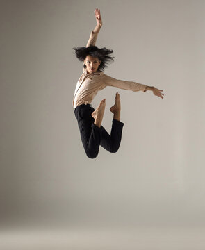 Male contemporary dancer leaping with hair flying