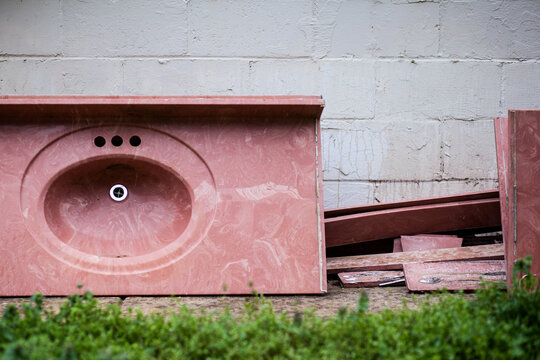 Pink sink and counter abandoned against building