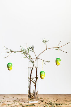 Two fir twigs loosing needles decorated with easter eggs