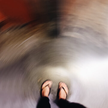 Looking down on the ground as it swirls around a woman's feet