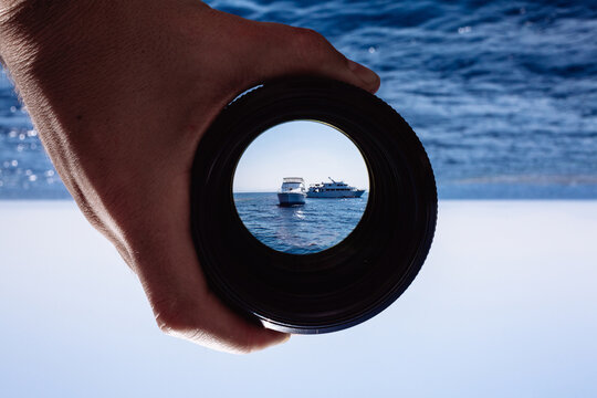 View through spyglass lens to the white distant cruise ships sailing on the Red Sea