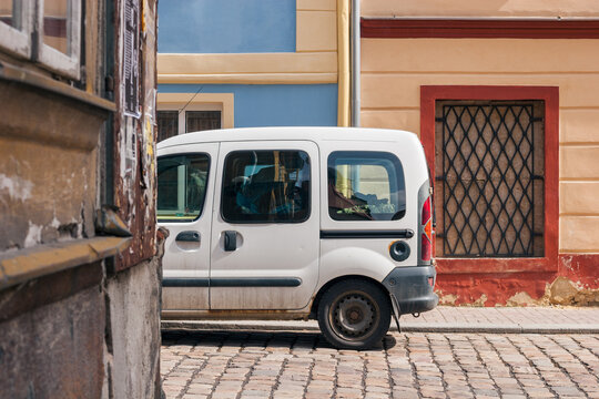 A Small Delivery Vehicle Parked Among Colorful Buildings in Cheb