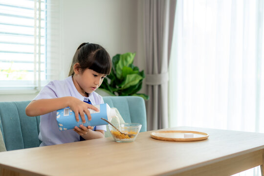 Asian Elementary School Student Girl In Uniform Eating Breakfast Cereals With Milk In Morning School Routine For Day In Life Getting Ready For School.