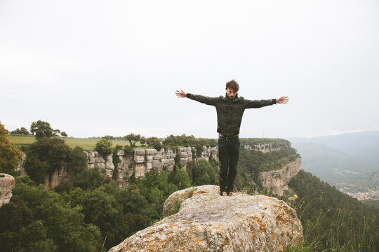 Young modern man on the top of the mountain.