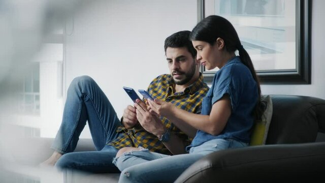 Man teaching woman how to use app on smartphone. Young people using cell phones for internet and social media. Boyfriend and girlfriend with mobile telephones technology