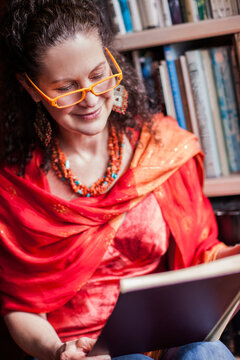 Middle age woman reading a book at home