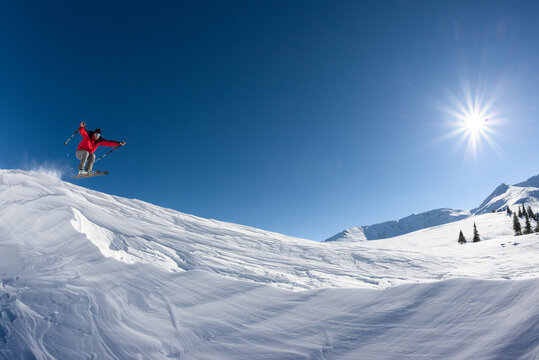 Skier with red jacket jumping