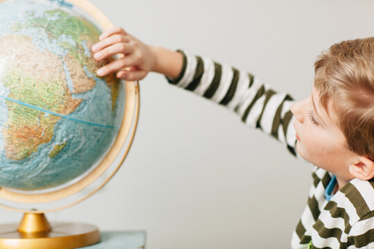 child studying a globe