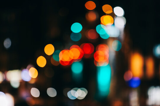 City traffic lights and car headlights at night, blurred focus