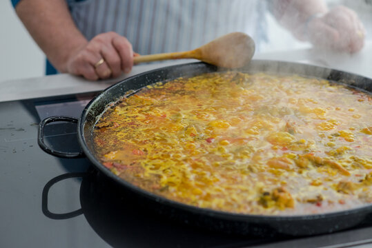 Mature spanish woman cooking paella