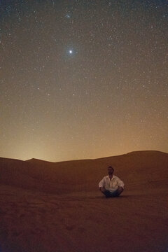Man sitting under the stars in the Desert