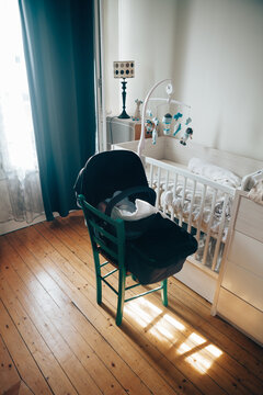Bassinet on a chair with newborn boy in his bedroom