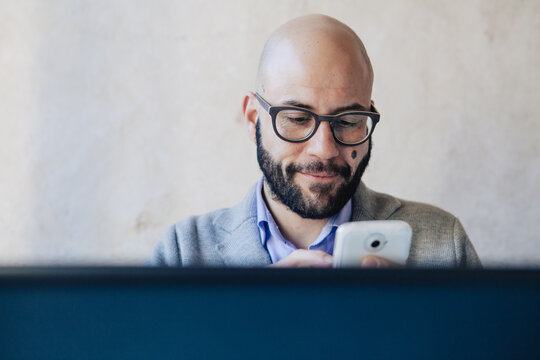 Smiling businessman using mobile phone