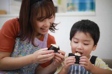 握ったおにぎりを食べる親子