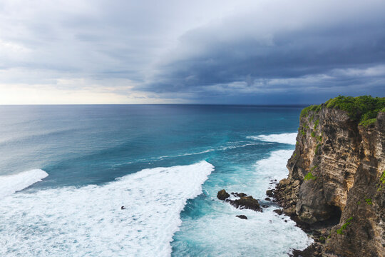 Cliff next to the braking surf ocean waves in Bali, Uluwatu