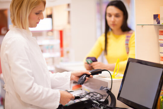 Pharmacist working with customer.