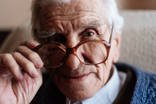 Portrait of senior man taking off his glasses