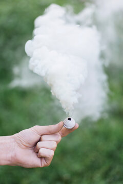 Hand holding a white smoke ball