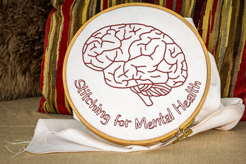 Stitching for mental health text with embroidered brain stitched on linen in embroidery hoop, craft for mental stimulation, meditation and to treat depression.