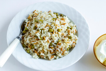 Traditional Turkish rice pilaf with peas and noodles in plate,top view