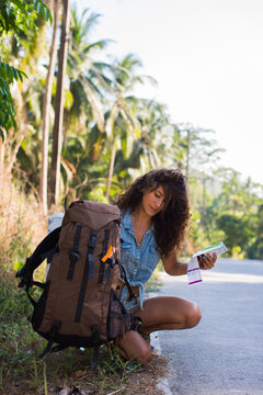 Woman Taking Map From Her Backpack