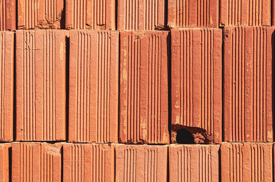 Red brick background with holes. 
Typical material of Brazilian civil construction.