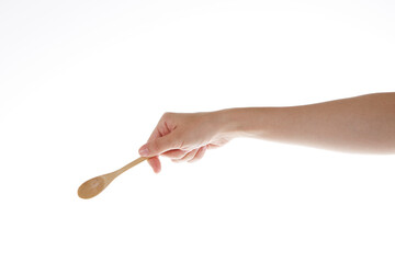 hand holding teaspoon made of wood.