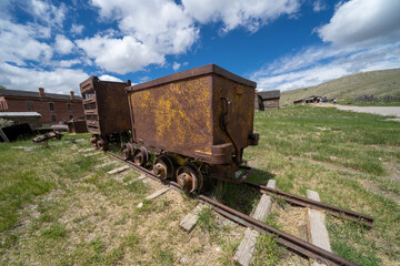 Fototapeta na wymiar Old mining ore carts and equipment, rusted, in Bannack Ghost Town in Montana