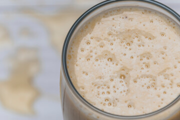 milkshake with banana, oats and cinnamon in a glass, top view, horizontal