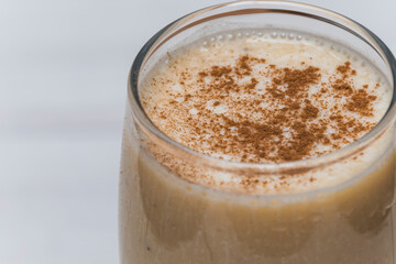 milkshake with banana, oats and cinnamon in a glass, top view, horizontal