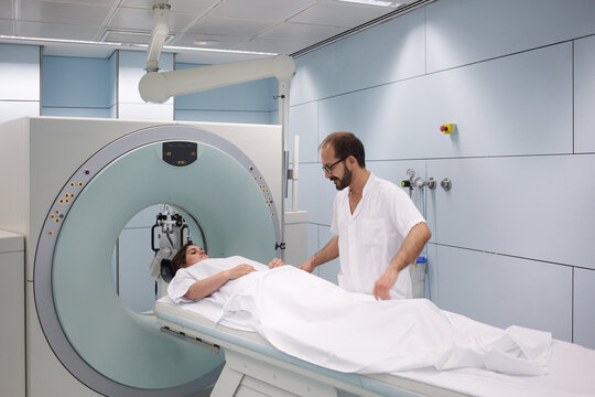Image diagnosis technician preparing a patient for the CT scann