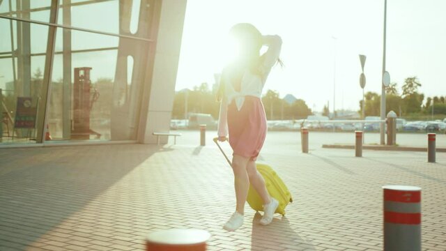 Chinese stressful asian woman traveler wearing casual clothes late for plane flight running with suitcase to airport terminal registration point hurrying up.