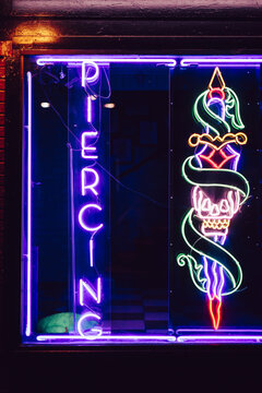 Neon Purple body piercing sign with graphic