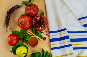 Prayer talit with shofar and traditional food for Rosh Hashanah.