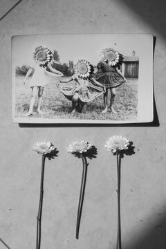 children with flowers over their faces,old photo in semi shade, friends