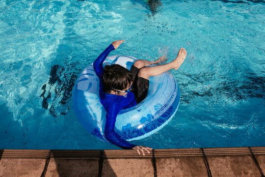 Young boy on a floater enjoying himself in the swimming pool