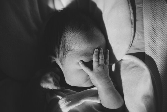 Newborn baby covering face