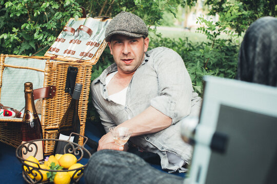 Spring Picnic - Portrait of Reclined Man Wearing Cabbie Hat Drinking Wine