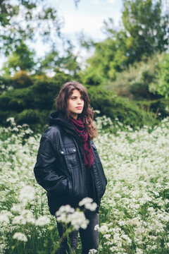 Woman in leather jacket amongst a field of white flowers