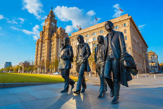 Liverpool, UK - May 17 2018: Bronze statue of the  Beatles stands at the Pier Head on the side of River Mersey, sculpted by Andrew Edwards and erected in December 2015