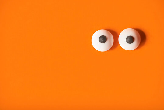 Halloween background, pair of eyes on orange